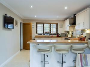 a kitchen with a island with bar stools at Ty Glyndwr in Ystalyfera