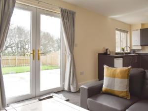 a living room with a couch and a sliding glass door at Seven Dorchester Drive - Uk32625 in Inglewhite