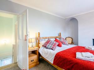 a bedroom with a bed with a red blanket at Beach House in Pakefield