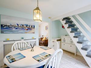 a dining room with a table and chairs and a staircase at Beach House in Pakefield