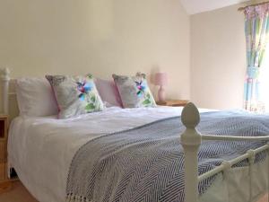 a bedroom with a large bed with pillows at Driftwood House in Sheringham