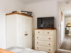 a bedroom with a tv on top of a dresser at Withymead Cottage in Withypool