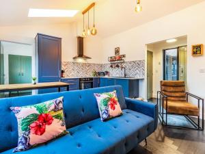 a blue couch in a living room with a kitchen at Lotties Luxurious Lodge - Uk36784 in Sutton Valence