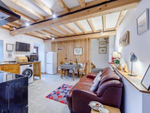 a living room with a brown leather couch and a kitchen at The Wool Loft - Uk31410 in Outhgill