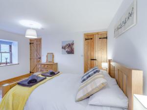 een slaapkamer met een wit bed en een houten hoofdeinde bij The Wool Loft - Uk31410 in Outhgill