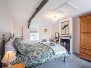 a bedroom with a bed and a fireplace at Flossys House -uk35020 in Chatton