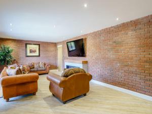 a living room with two couches and a brick wall at The Barnacle Goose - Uk35261 in Bowness-on-Solway