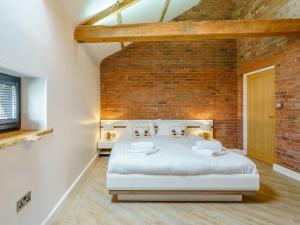 a bedroom with a brick wall and a bed at The Barnacle Goose - Uk35261 in Bowness-on-Solway