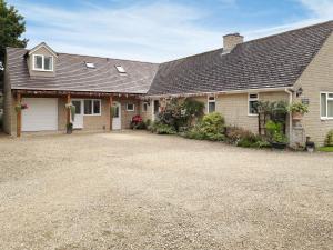 a house with a driveway in front of it at Herons Nest in Bourton on the Water