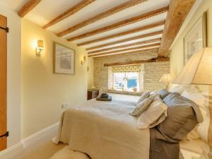 een slaapkamer met een groot bed in een kamer bij The Clock House in Bisley