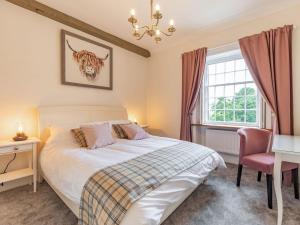 a bedroom with a bed and a desk and a window at Catmint Cottage in Highpeak Junction