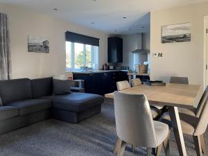 a living room with a couch and a dining room table at Kestrel View in Skipton