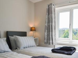 a bedroom with two beds and a window at Kestrel View in Skipton