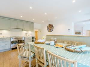 a kitchen with a table and chairs and a kitchen with a clock at Inner Lodge in Bolton by Bowland
