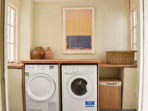 uma lavandaria com máquina de lavar e secar roupa em Coachmans Close em Milverton