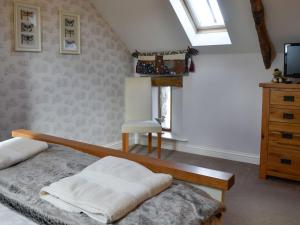 a bedroom with a bed and a dresser and a window at Swallow Barn in Torpenhow