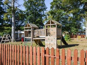 a wooden playground with two play structures behind a fence at Meadow Crest in Belton