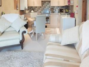 a living room with two couches and a kitchen at Hilltop - East Wing in Newton Stewart