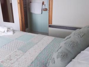 a bed with a quilt on it in a room at Hilltop - East Wing in Newton Stewart