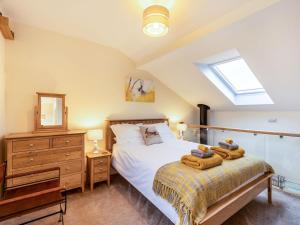 a bedroom with a bed and a dresser and a window at Ferny Rigg Byre - Uk3326 in Falstone