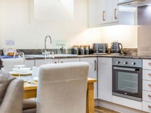 eine Küche mit weißen Schränken und einem Holztisch in der Unterkunft Ferny Rigg Byre - Uk3326 in Falstone