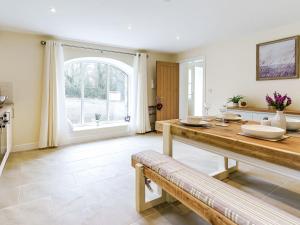a kitchen with a wooden table and a large window at Ty Draenog - Uk31653 in New Quay