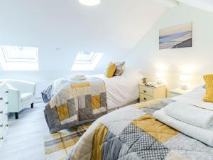 a bedroom with two beds and a desk at Ty Draenog - Uk31653 in New Quay
