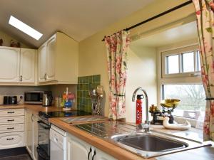 a kitchen with a sink and a window at High Dalton Hall Cottage in Newsham