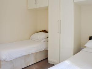 a small bedroom with two beds and white cabinets at Lodge F- Uk33092 in Dinnet
