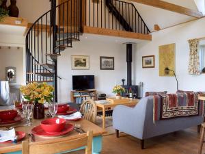 - un salon avec une table et un escalier dans l'établissement The Cottage, à Lane to Richards Castle