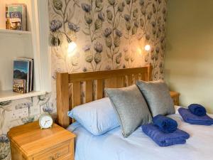 a bedroom with a bed with blue pillows at Hollybank in Ladybank