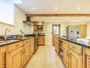 a large kitchen with wooden cabinets and stainless steel appliances at The Old School in Carlton