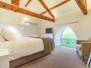 a bedroom with a large bed and an arched window at The Old School in Carlton