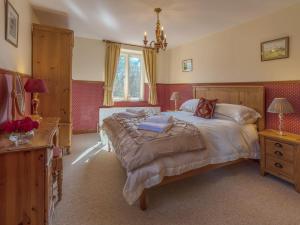 a bedroom with a large bed and a window at Ashby Cottage in Long Compton