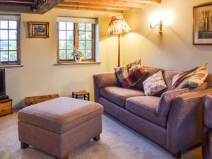 a living room with a couch and a ottoman at Waen Farm Cottage in Tremeirchion
