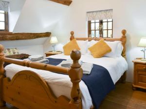 a bedroom with a wooden bed with a blue blanket at Waen Farm Cottage in Tremeirchion