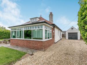 an exterior view of a brick house with a garage at Summer House in Sutton on Sea