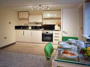 uma cozinha com armários brancos e uma mesa com comida em Uphempston Farm House Annex em Totnes