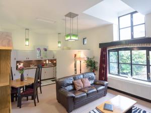 a living room with a leather couch and a table at Deco-uk12749 in Menheniot