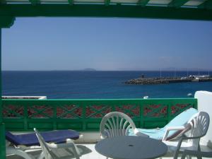 a balcony with chairs and a table and the ocean at Apartamentos Las Clacas in Playa Blanca