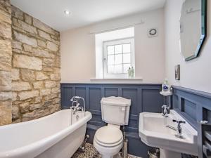 a bathroom with a tub and a toilet and a sink at Hillside Cottage in Haltwhistle