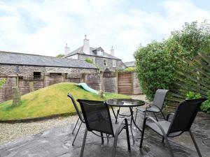 a patio with a table and chairs and a hill at Deco-uk12749 in Menheniot