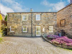 an old brick building with a driveway in front of it at Hillside Cottage in Haltwhistle