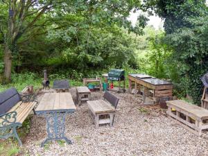 a group of picnic tables and benches in a yard at Shepherds Hut 2 At Laddingford - Uk32534 in Yalding