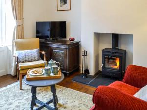 a living room with a fireplace and a stove at Sinclairs in Gatehouse of Fleet