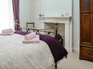 a bedroom with a bed with pink towels on it at Sinclairs in Gatehouse of Fleet