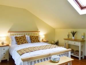 a bedroom with a white bed with two night stands at Garden Cottage in Sabden
