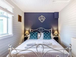 1 dormitorio con 1 cama blanca y paredes azules en Holly Tree Cottage, en Tain