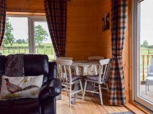 jadalnia ze stołem i krzesłami oraz oknem w obiekcie Pheasant Lodge - Uk33402 w mieście Hungerton
