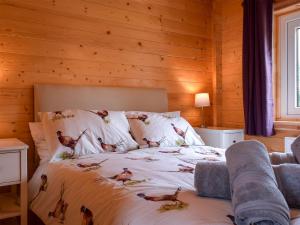 sypialnia z łóżkiem z ptakami na prześcieradle w obiekcie Pheasant Lodge - Uk33402 w mieście Hungerton